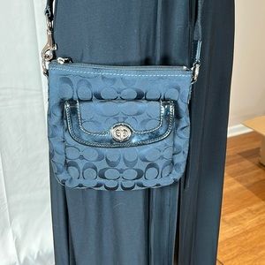 Black crossbody Coach bag with black patent accents.